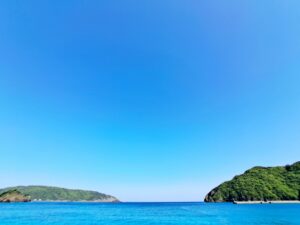 奄美大島・名瀬の空と海。澄んだ青空とエメラルドブルーの海が織りなす、南国の穏やかな絶景。